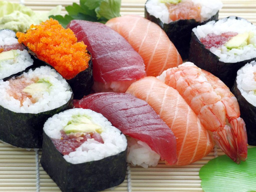 plate full of different types of sushi rolls